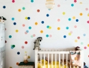 Adore the colorful polka dots wall with gold accents in the baby room | 10 Colourful Nurseries - Tinyme Blog